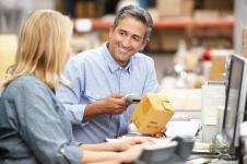 business colleagues working at desk in warehouse P86VKL2